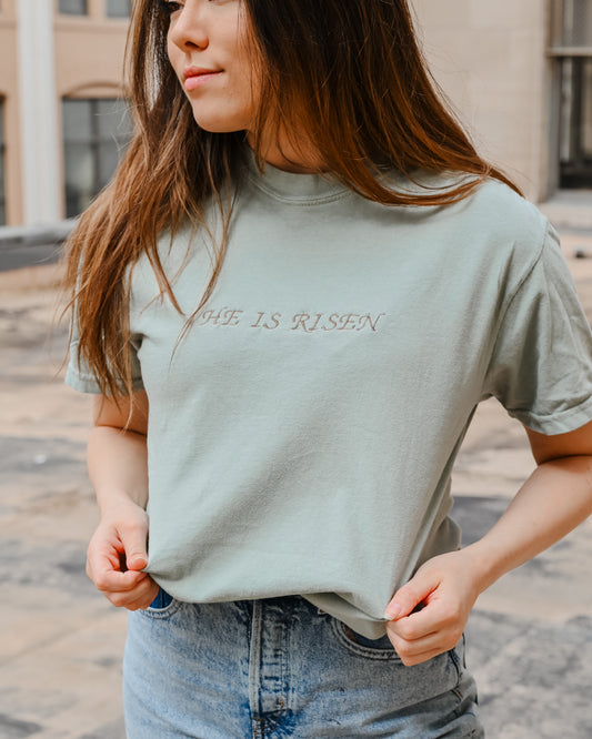 Sage green embroidered “HE IS RISEN” tee shirt